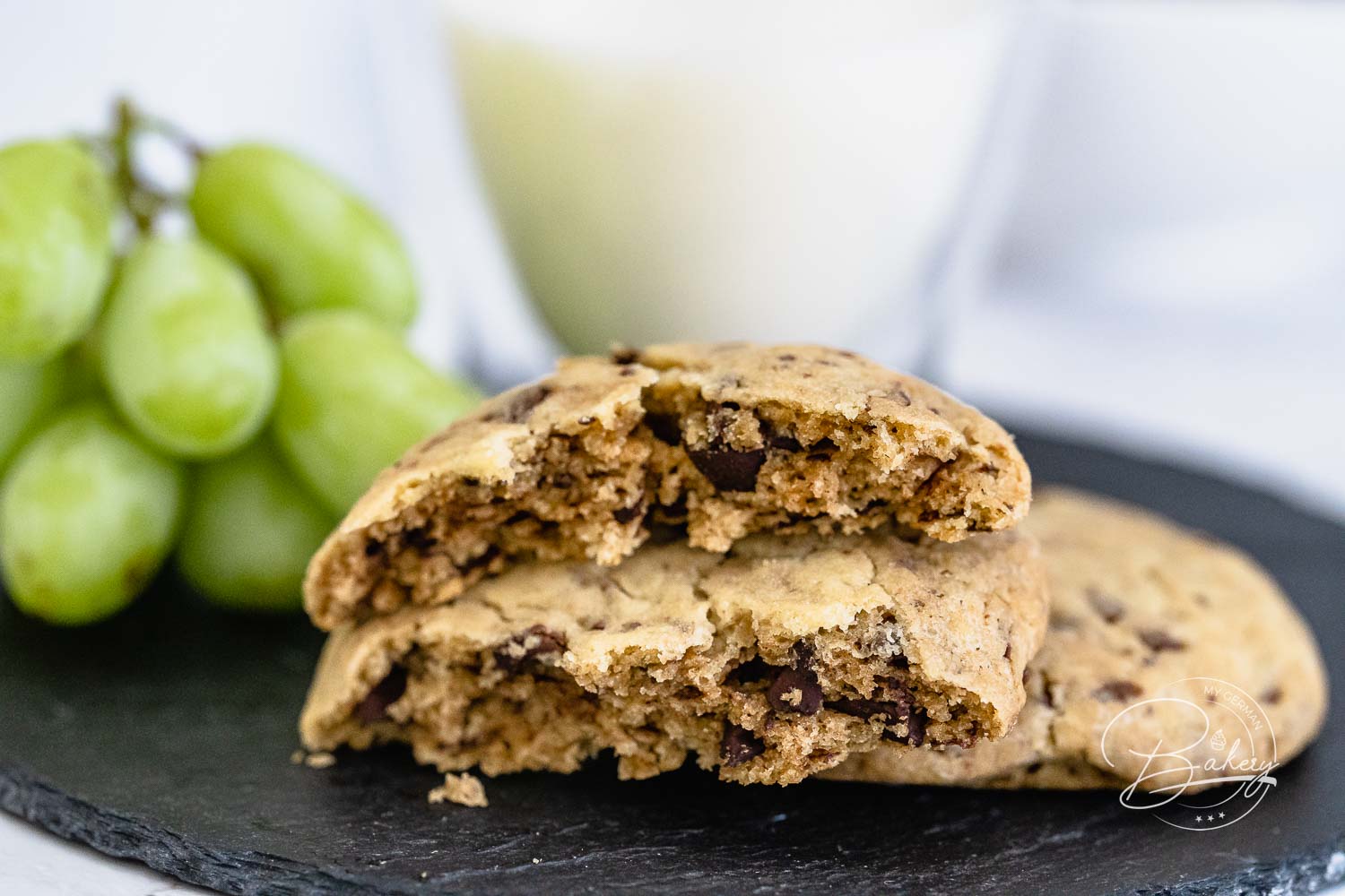 Einer der Chocolate Chip Cookies aufgebrochen, mit weichem Kern und dunklen Schokostückchen