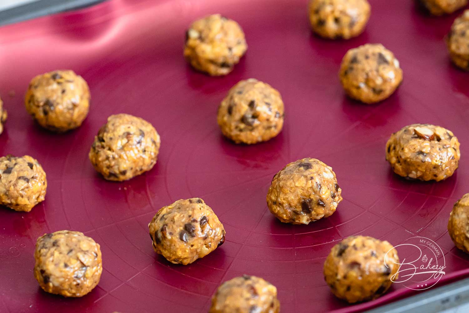 Rohe Teigkugeln der Kekse auf dem Backblech vor dem Backen