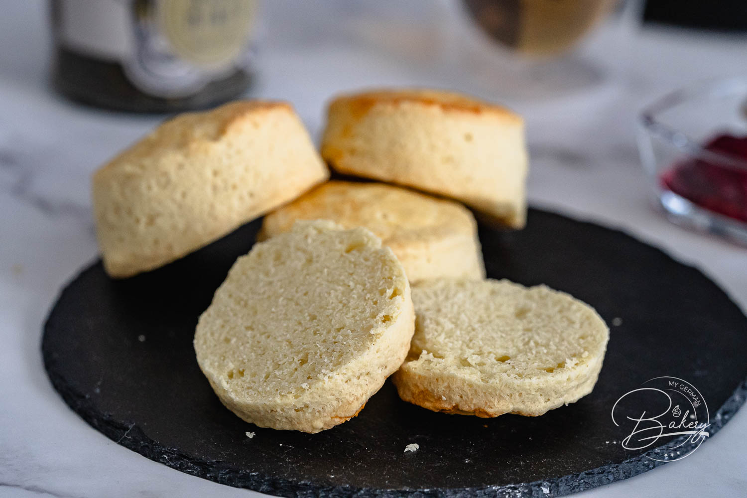 Aufgeschnittene Scones mit weicher heller Krume auf einer dunklen Schieferplatte